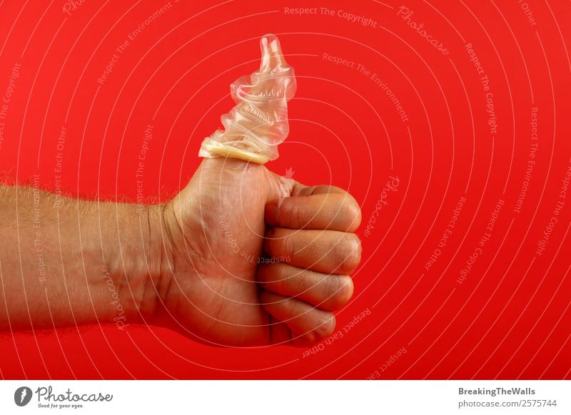 Nahaufnahme Männerhand mit Daumen nach oben mit Kondom am Finger Gesundheit Gesundheitswesen maskulin Junger Mann Jugendliche Erwachsene Hand 1 Mensch genießen