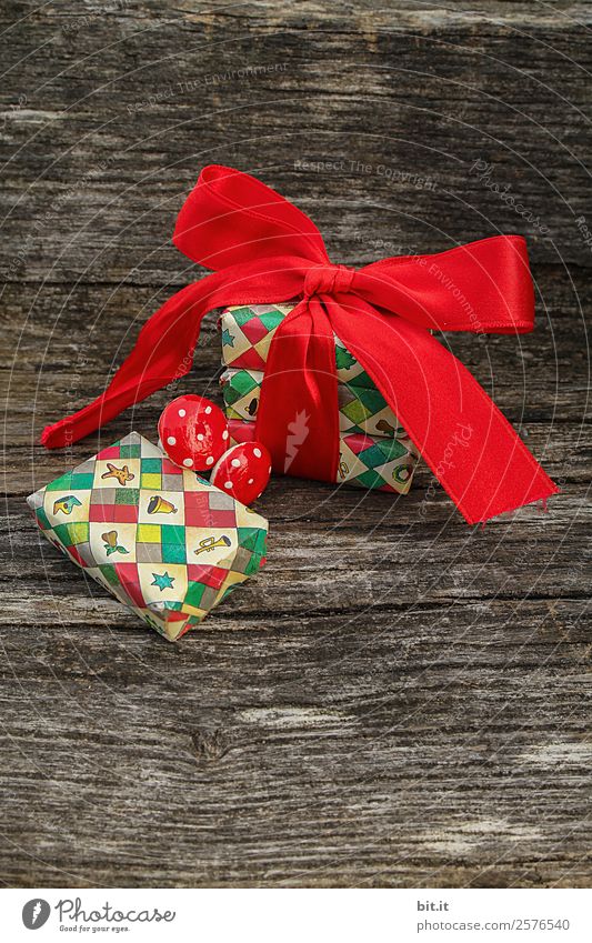 Weihnachtspäckchen mit roter Schleife auf Holzhintergrund. Feste & Feiern Weihnachten & Advent braun mehrfarbig Weihnachtsdekoration Weihnachtsgeschenk Pilz