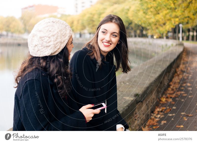 Mädchen unterhalten sich im Freien Lifestyle Freude Glück schön Sitzung sprechen Telefon PDA Technik & Technologie Internet Mensch Frau Erwachsene Freundschaft