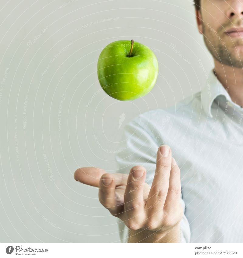 Mann jongliert mit einem grünen Apfel Lebensmittel Frucht Ernährung Essen Frühstück Picknick Bioprodukte Vegetarische Ernährung Diät Freude Glück Gesundheit