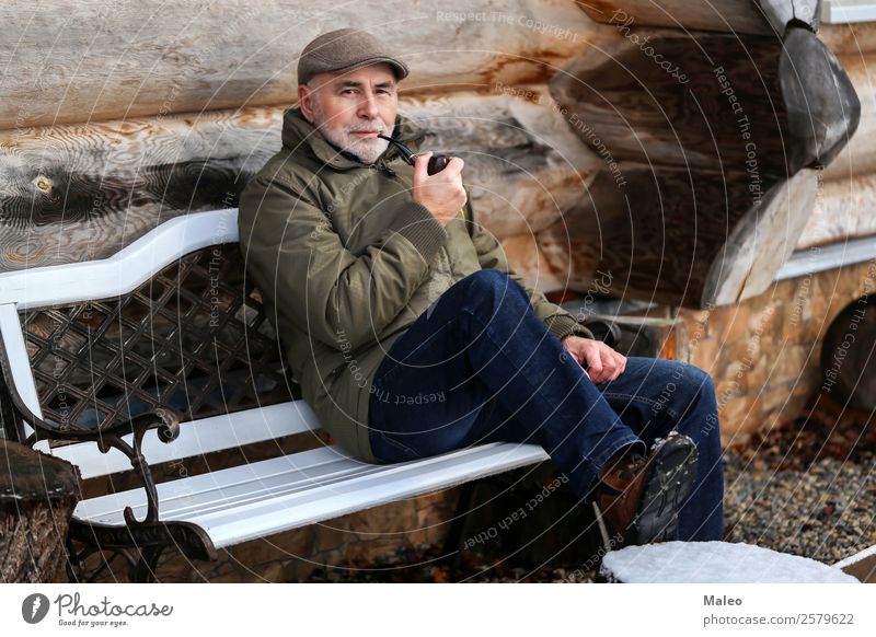Der Mann raucht eine Pfeife sitzen Bank Rauchen Tabakwaren Haus kalt Winter Holz Bart Erwachsene Mensch