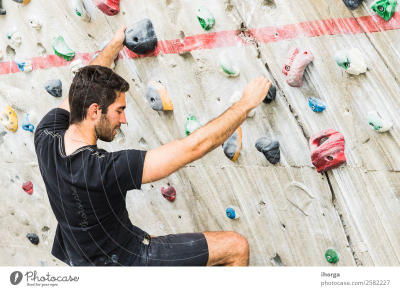 Ein Mann übt das Klettern an einer künstlichen Wand in Innenräumen. Lifestyle Freude Freizeit & Hobby Sport Bergsteigen Junger Mann Jugendliche Erwachsene 1