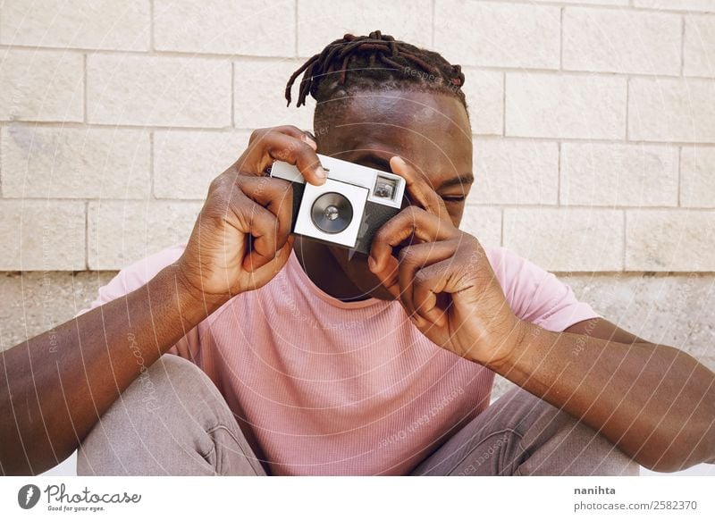 Junger Mann, der mit einer Kamera fotografiert. Lifestyle Stil Design Freizeit & Hobby Arbeit & Erwerbstätigkeit Beruf Fotokamera Technik & Technologie