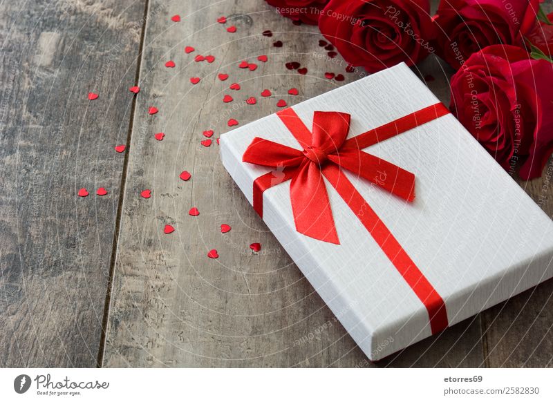 Geschenkbox und rote Rose auf Holzuntergrund, Valentinstag-Konzept Kasten Muttertag Geburtstag romantisch Feste & Feiern Liebe Blume Gruß