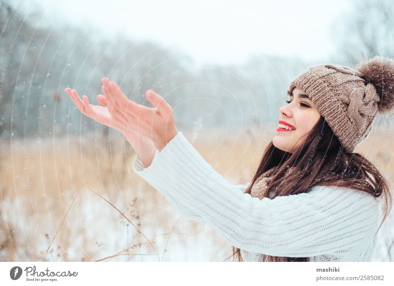 glückliche Frau, die beim Spaziergang Schneeflocken fängt. Stil Freude Glück Gesicht Schminke Lippenstift stricken Ferien & Urlaub & Reisen Winter feminin