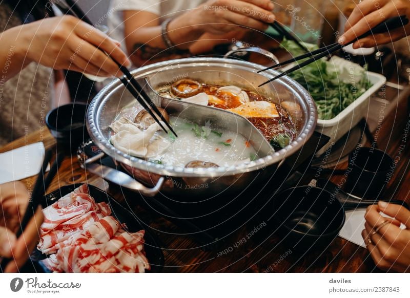 Koreanischer Hot Pot und Menschen, die mit Stäbchen essen. Fleisch Meeresfrüchte Gemüse Suppe schmoren Essen Topf Lifestyle Ferien & Urlaub & Reisen Restaurant
