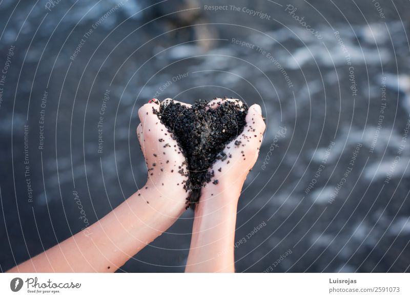 Mädchenhände mit schwarzem herzförmigen Sand Freude Gesundheit Sinnesorgane ruhig Spa Massage Ferien & Urlaub & Reisen Strand Meer Wellen Frau Erwachsene Hand