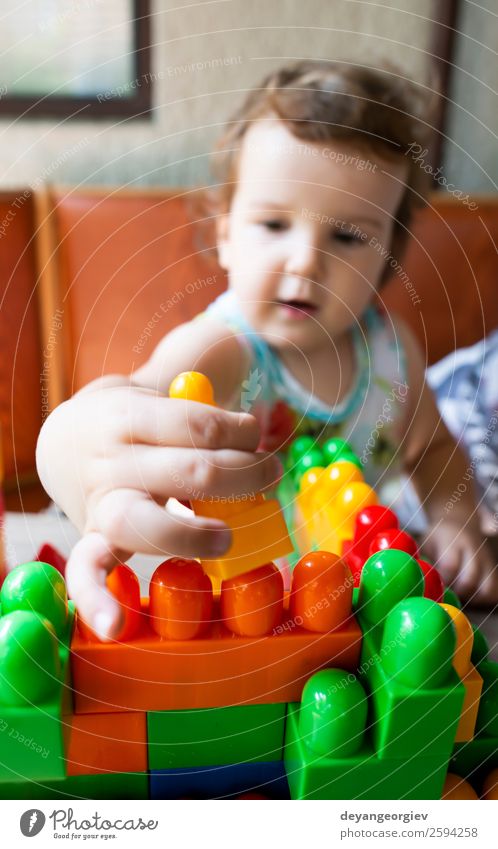 Kleines Mädchen spielt mit Spielzeugblöcken Freude Glück Freizeit & Hobby Spielen Kind Kindheit Hand Gebäude Kunststoff bauen sitzen klein Farbe Kreativität
