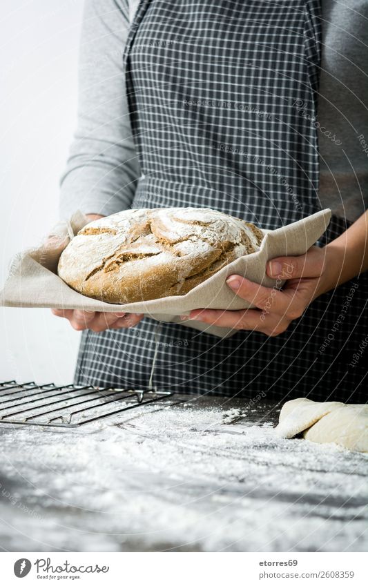 Frau, die zu Hause handgemachtes Brot zeigt. machen knien Hand Küche Schürze Mehl Hefe selbstgemacht backen Teigwaren Mensch Vorbereitung rühren Zutaten roh