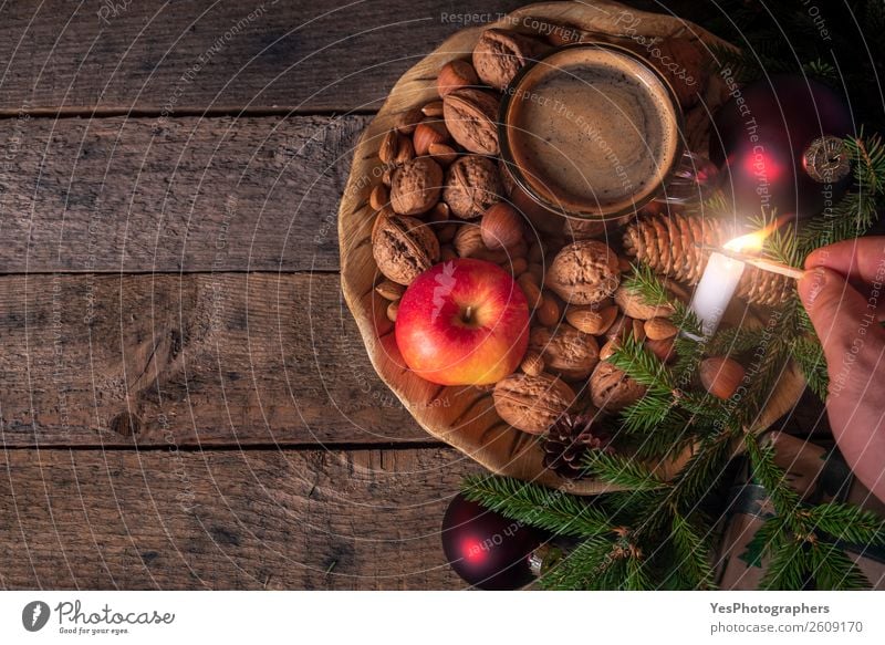 Mann zündet eine Kerze im Weihnachtsschmuck an. Lifestyle Gesunde Ernährung Erholung Freizeit & Hobby Winter Dekoration & Verzierung Tisch Tradition