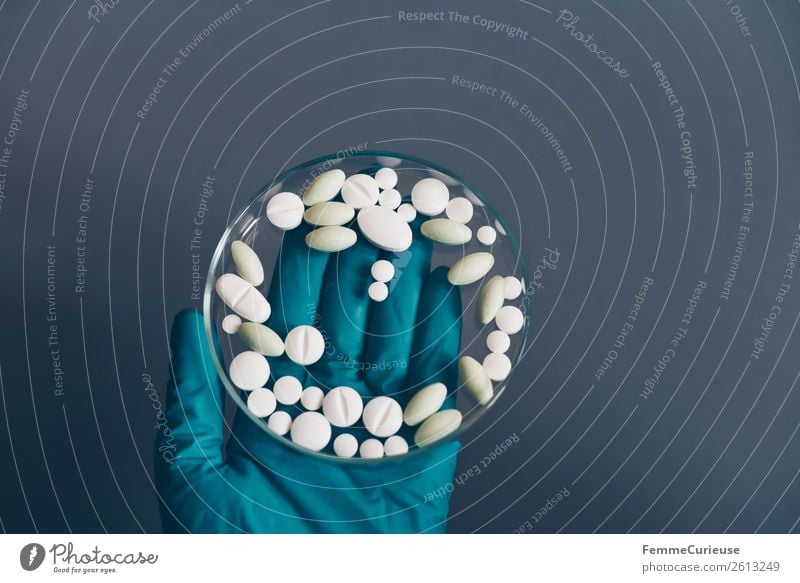 Hand in medical glove with medication in petri dish Wissenschaften Fortschritt Zukunft Gesundheit Medikament Tablette Heilung Petrischale durchsichtig