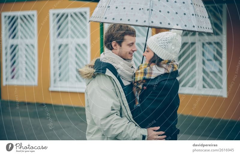 Junges Paar, das an einem regnerischen Tag im Freien unter dem Regenschirm steht. Lifestyle Glück schön Winter Mensch Frau Erwachsene Mann
