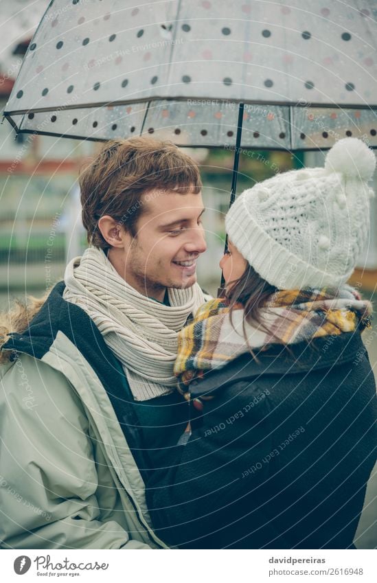 Junges Paar umarmt unter Regenschirm in einem regnerischen Tag Lifestyle Glück schön Winter Mensch Frau Erwachsene Mann Familie & Verwandtschaft Herbst Straße