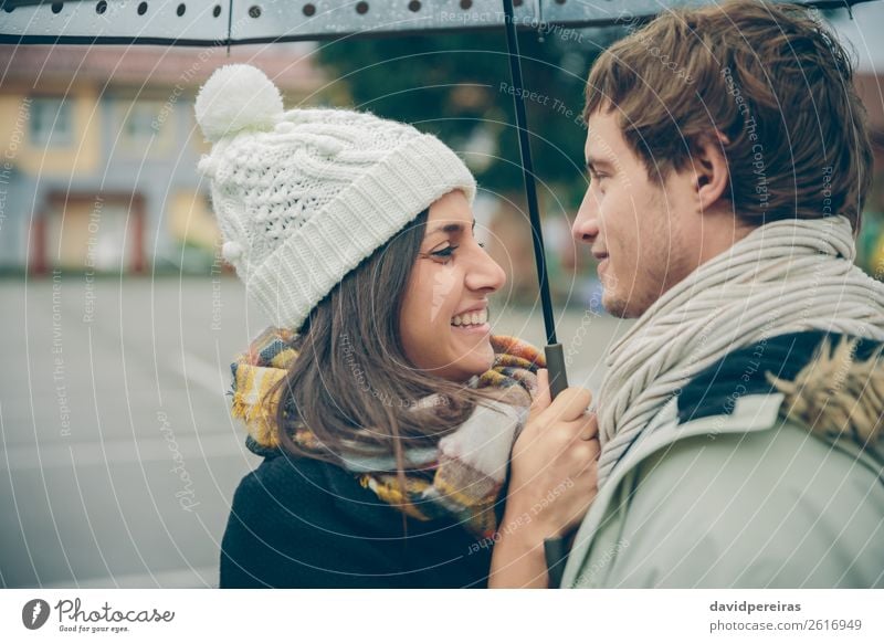 Junges Paar, das sich im Freien unter dem Regenschirm umarmt und lacht. Lifestyle Glück schön Winter Mensch Frau Erwachsene Mann Familie & Verwandtschaft Herbst