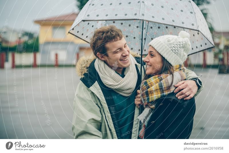 Paar umarmt und lachend unter Regenschirm in einem regnerischen Tag Lifestyle Glück schön Winter Mensch Frau Erwachsene Mann Familie & Verwandtschaft Herbst