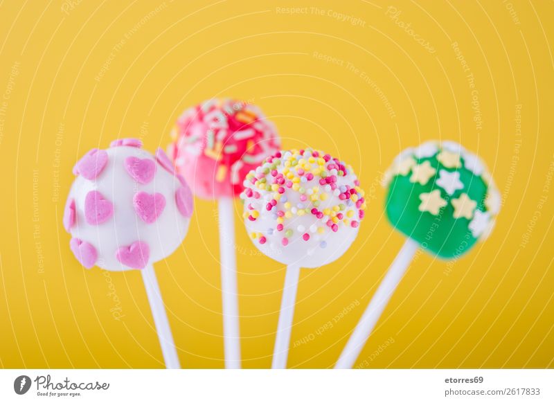 Süße Kuchenpops auf gelbem Hintergrund Backwaren süß Bonbon Pop Farbe mehrfarbig Lebensmittel Foodfotografie Lollipop backen Hundefutter Stock rosa Dessert hell