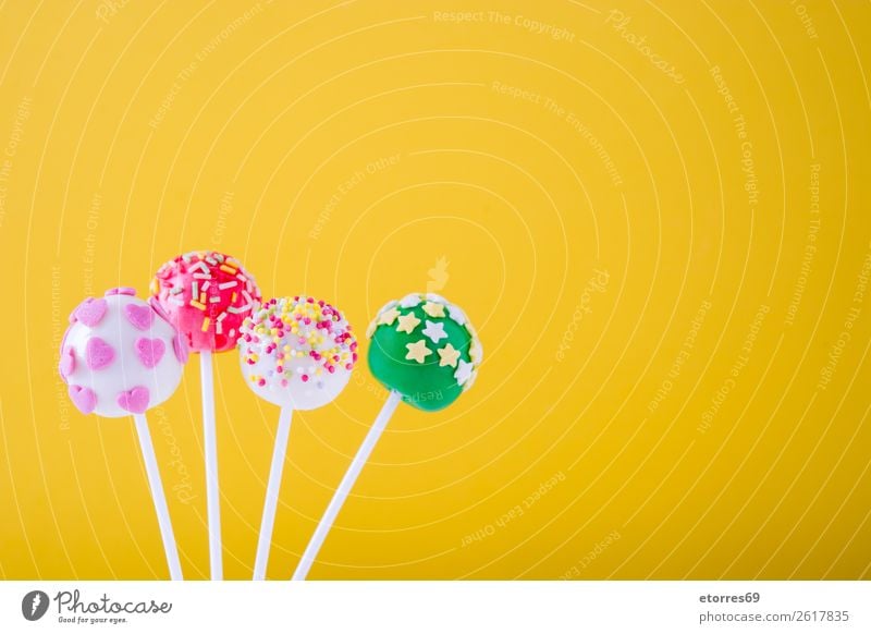 Süße bunte Kuchenpops auf gelbem Hintergrund Backwaren süß Bonbon Süßwaren Pop Farbe mehrfarbig Lebensmittel Foodfotografie Lollipop backen Hundefutter Stock