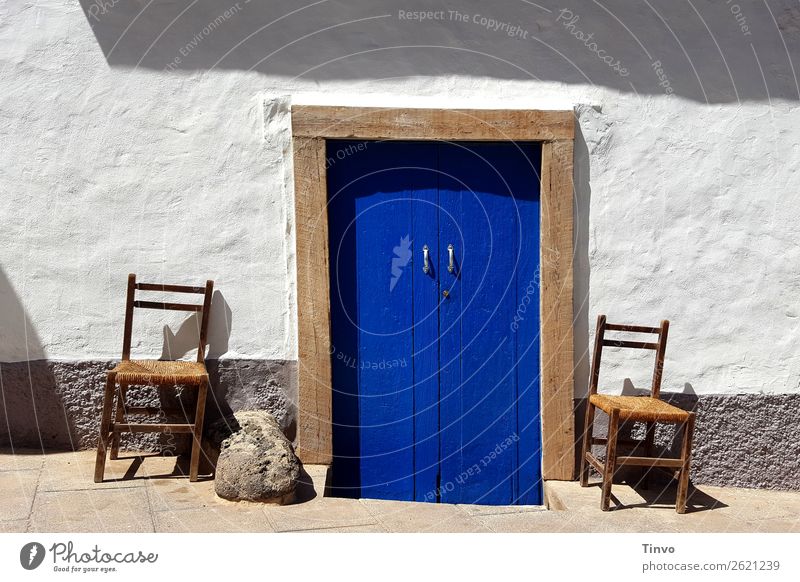 Blaue Tür und 2 Stühle an mediterraner weißer Hauswand Sommer Wohnung Dorf Fischerdorf Gebäude Mauer Wand Fassade frisch blau braun Stuhl Spanien Griechenland