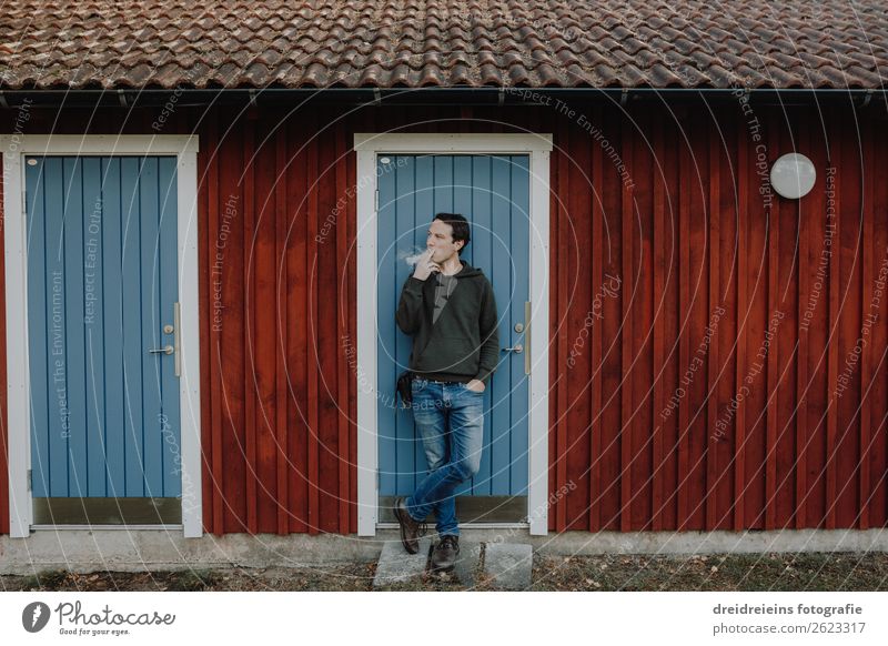 Mann steht vor Schwedenhaus Blockhütte und raucht Zigarette Lifestyle Mensch maskulin Erwachsene Hütte Rauchen stehen trendy selbstbewußt Coolness Optimismus