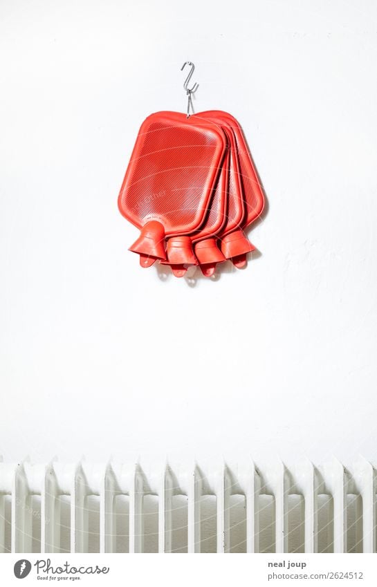 Rote Wärmflaschen hängen über einem weißen Heizkörper Energie sparen Wohlgefühl Heizung Wand frieren ästhetisch Billig einzigartig kalt rot Warmherzigkeit
