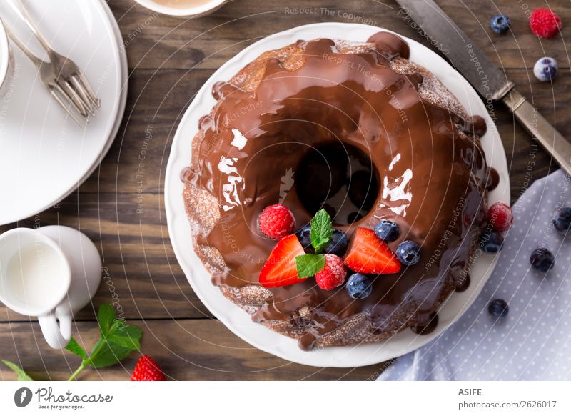 Schokoladen-Bundtorte mit Beeren Frucht Dessert Frühstück Kakao Kaffee Tee Geburtstag Blatt Holz frisch braun Kuchen Bundkuchen Glasur Erdbeeren Brombeeren