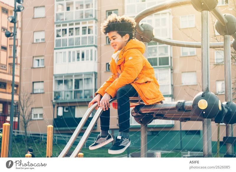 Glücklicher kleiner Junge, der Spaß auf einem städtischen Spielplatz hat. Freude Freizeit & Hobby Spielen Winter Klettern Bergsteigen Kind Mann Erwachsene