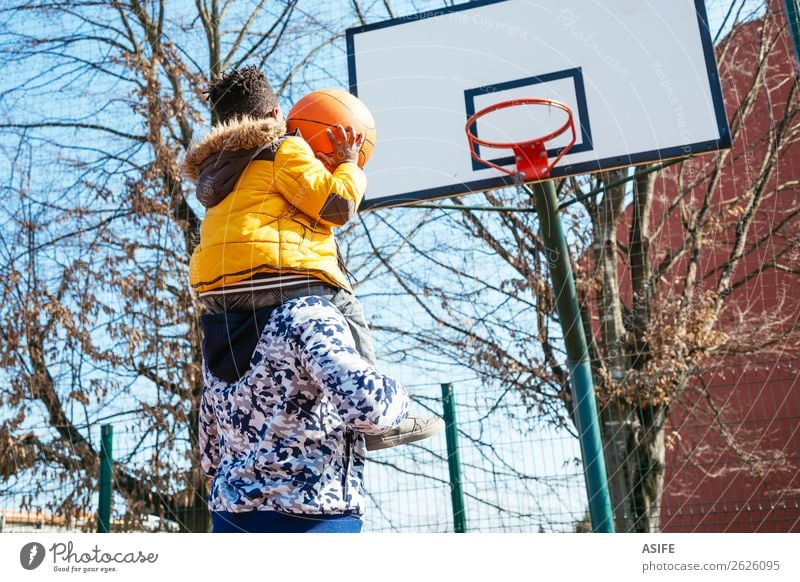 Kleiner Junge auf daddy´s Schulter spielt Basketball Freude Glück Erholung Freizeit & Hobby Spielen Winter Sport Schule Eltern Erwachsene Vater