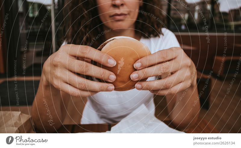 Junges Mädchen mit Fastfood-Burger in der Hand Lebensmittel Brot Mittagessen Lifestyle Stil schön Mensch Frau Erwachsene Straße Mode Fröhlichkeit lecker