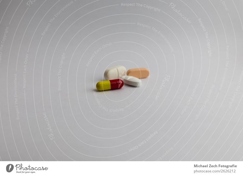 Pillen in verschiedenen Farben auf weißem Hintergrund Schalen & Schüsseln Behandlung Krankheit Medikament Wissenschaften Holz blau gelb rosa rot Tablette