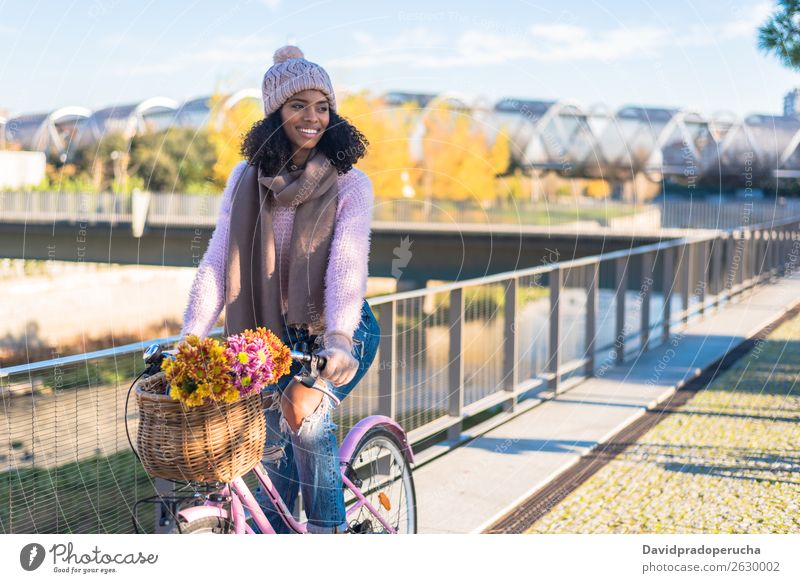 Schwarze junge Frau auf einem Oldtimer-Fahrrad altehrwürdig Korb Mädchen Person gemischter Abstammung schön retro Blume Glück Blumenstrauß Winter Herbst