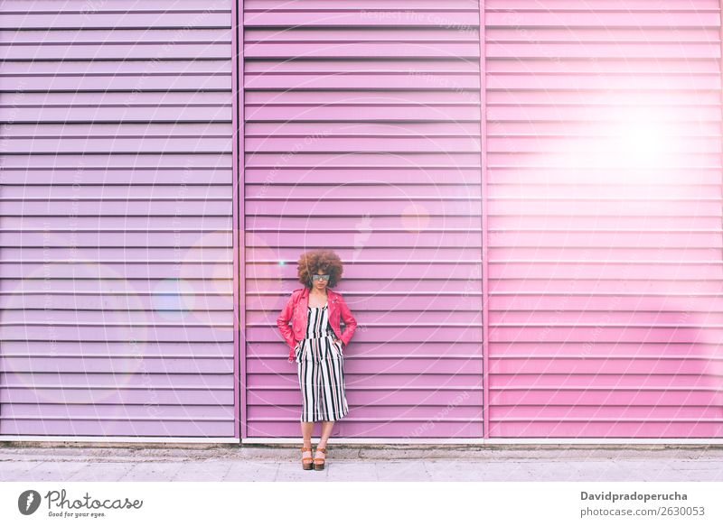 Gemischte Rassenfrau in einem mehrfarbigen Wandhintergrund Frau Lächeln gemischt Porträt schwarz Lifestyle Hintergrundbild multiethnisch rosa Wegsehen urwüchsig