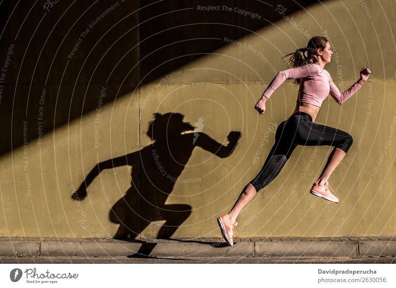 Junge, fitte, blonde Frau, die auf der Straße springt. springen rennen üben Fitness ausarbeiten Lifestyle Bewegung Aktion Joggen Profil horizontal sportlich