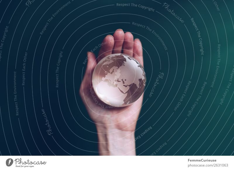 Hand with transparent globe in front of green background Klima Horizont Erde Globus durchsichtig festhalten Finger dunkelgrün Europa Afrika Saudi-Arabien