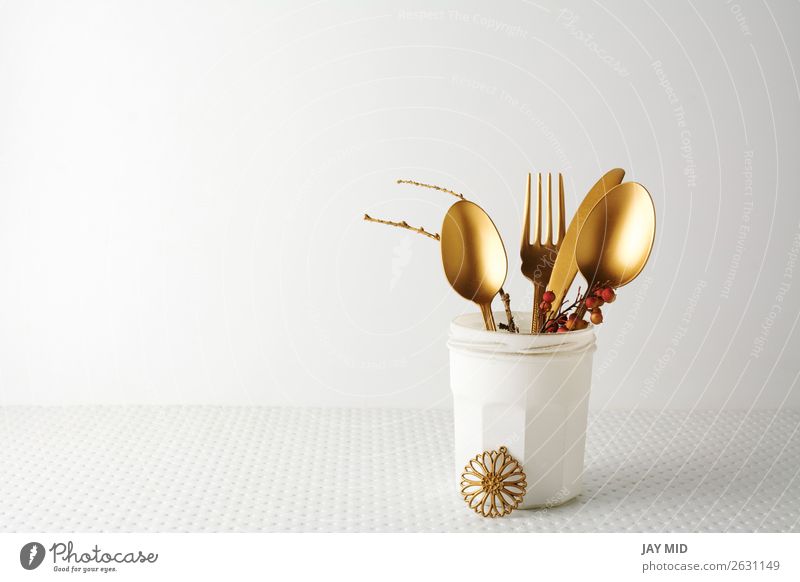 Festliches goldenes Besteckmesser und Gabellöffel in einer weißen Flasche. Mittagessen Abendessen Löffel elegant Design Dekoration & Verzierung Tisch Küche