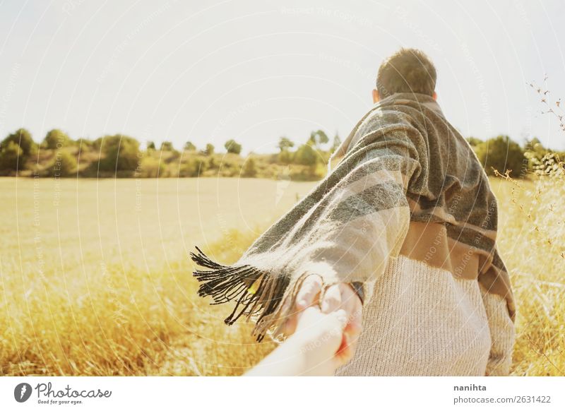 Ein Mann, der die Hand seines Paares auf einem Feld hält. Lifestyle Wellness harmonisch Abenteuer Ferne Freiheit Sommer Mensch maskulin Erwachsene