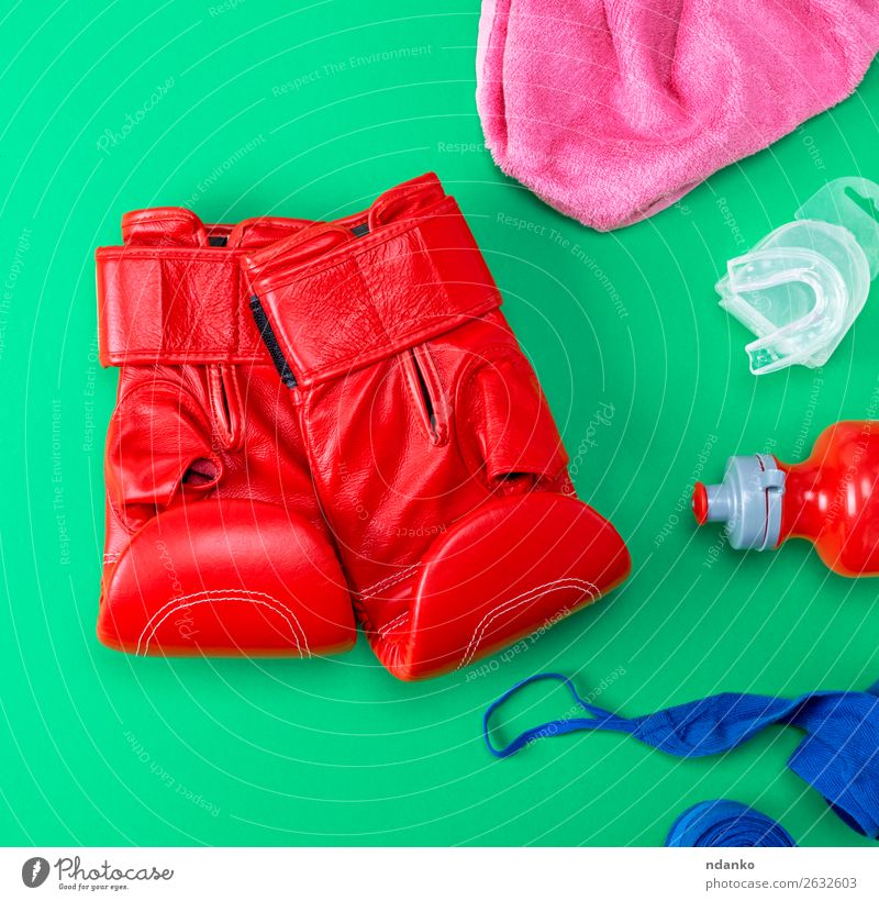 rote Leder-Boxhandschuhe, eine Plastik-Wasserflasche. Flasche Lifestyle Fitness Sport Leichtathletik Handschuhe oben blau grün rosa Schutz Farbe Konkurrenz