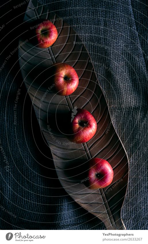 Rote Äpfel auf einem Holztablett bei schlechten Lichtverhältnissen Frucht Apfel Gesunde Ernährung Herbst dunkel frisch lecker natürlich retro rot obere Ansicht