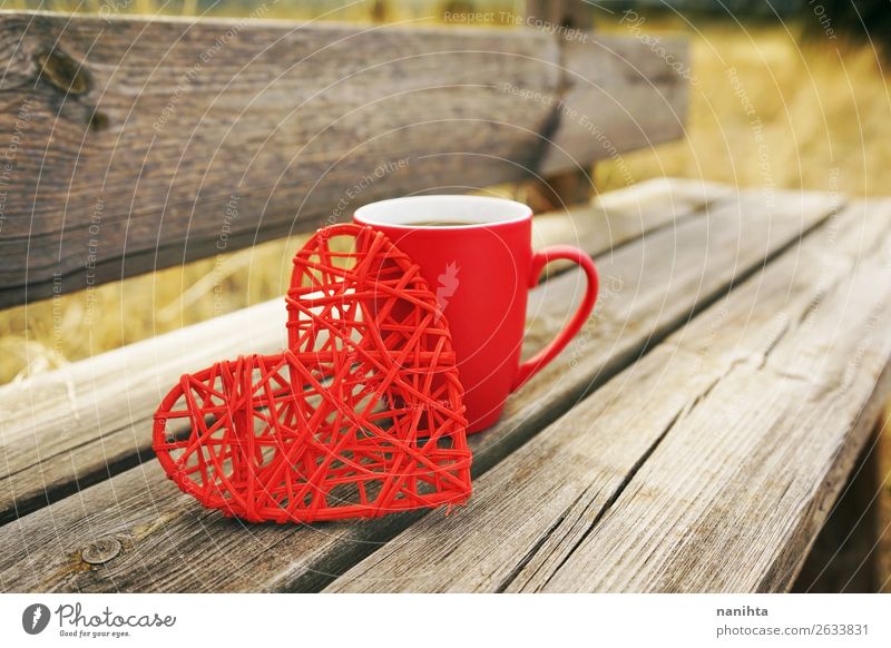 Rote Tasse mit Kaffee auf einer Holzbank im Freien am Morgen. Frühstück Getränk Heißgetränk Tee Becher Winter Herbst Wärme Herz frisch Gesundheit lecker