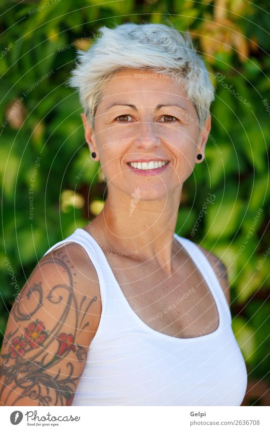Frau mit geblümten Tattoos auf dem Arm. Lifestyle Stil Glück schön Körper Sommer Erwachsene Arme Punk Natur Pflanze Blume Park Mode Schmuck blond Lächeln