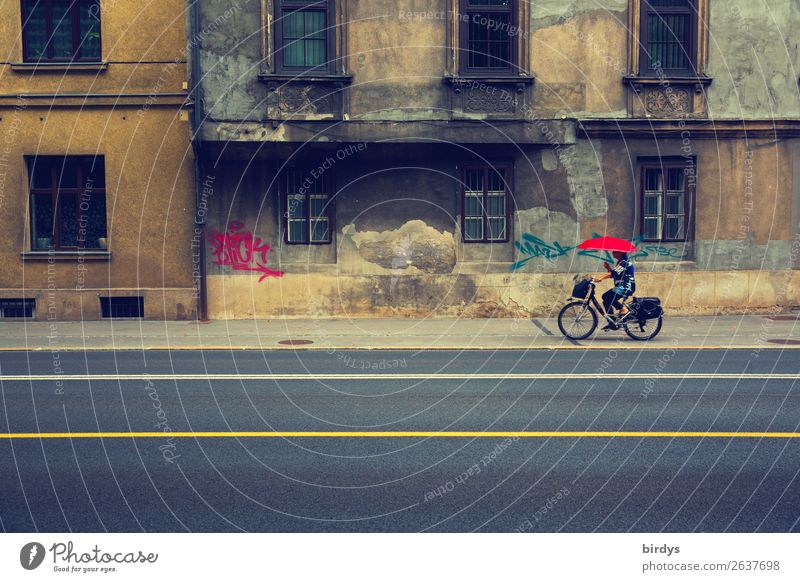 Fahrradfahrerin mit rotem Regenschirm vor baufälligem Gebäude im urbanan Raum Lifestyle feminin Frau Erwachsene 1 Mensch 45-60 Jahre Fahrradfahren