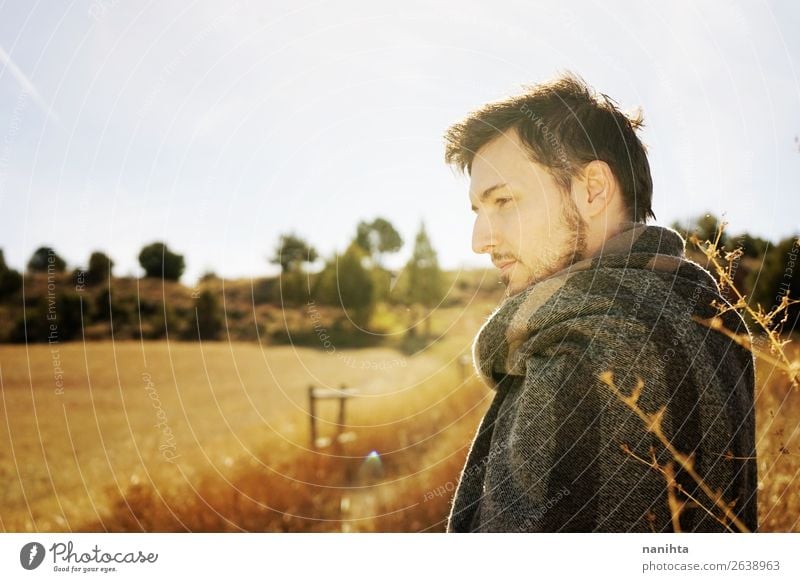 Seitenporträt eines jungen Mannes, der den Morgen genießt. Lifestyle Glück Gesicht Erholung ruhig Freiheit Sonnenbad Erwachsene Himmel Herbst Gras Schal