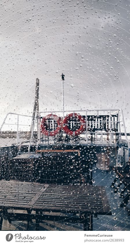 View from the inside of a boat to window with raindrops Wasser Wassertropfen Bewegung Wetter Wetterumschwung Regen Regenwasser Regenwolken Fensterscheibe