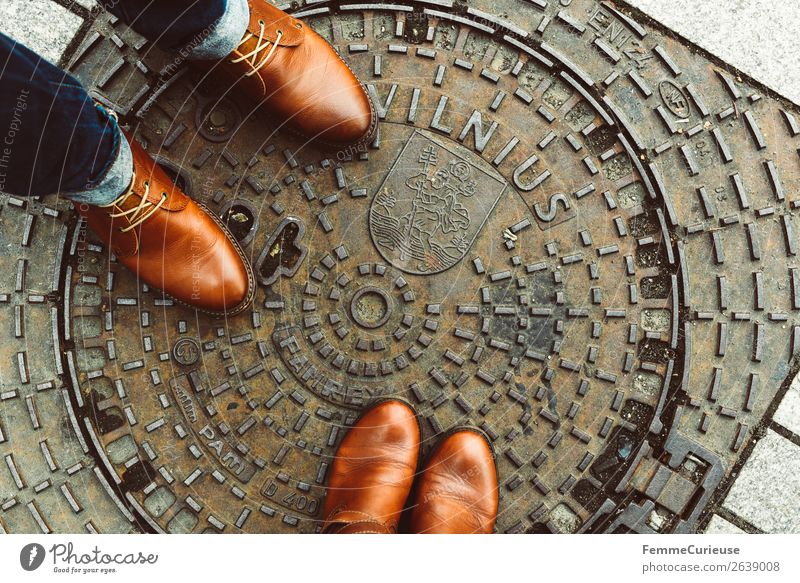 Two persons in brown leather shoes on manhole cover in Vilnius elegant Stil maskulin feminin Frau Erwachsene Mann 2 Mensch Ferien & Urlaub & Reisen Gully Wappen