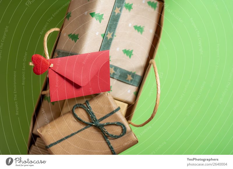 Roter Umschlag, auf den Griff geklemmt, aus einer Geschenkverpackung. Feste & Feiern Weihnachten & Advent Papier Fröhlichkeit grün rot Überraschung Tradition