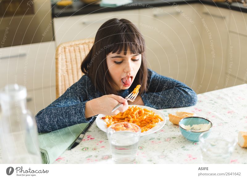 Kleines Mädchen isst zu Hause Nudeln Käse Ernährung Essen Mittagessen Abendessen Gabel Freude Glück schön Tisch Küche Kind sitzen lecker niedlich