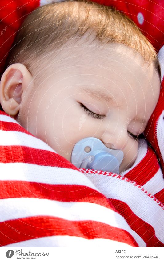 Bezaubernder Babyschlaf in einer roten Decke verpackt. Gesicht Leben Erholung Sommer Sonne Kind Mensch Junge Kindheit Kinderwagen Streifen schlafen träumen