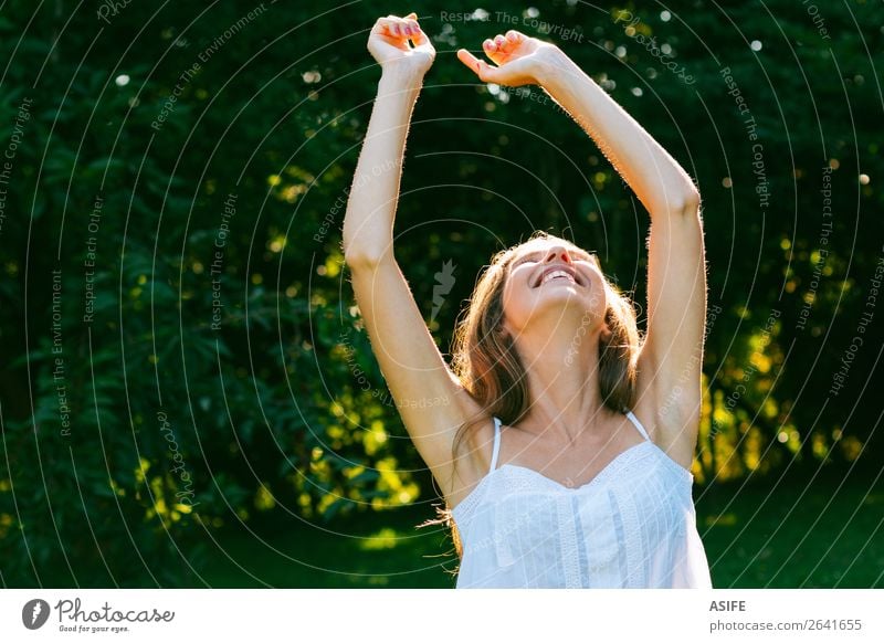 Glückliche Frau genießt die Sonne Freude Wellness Erholung Freiheit Sommer Erwachsene Natur Wärme Baum Park Wald Lächeln lachen Fröhlichkeit frisch niedlich