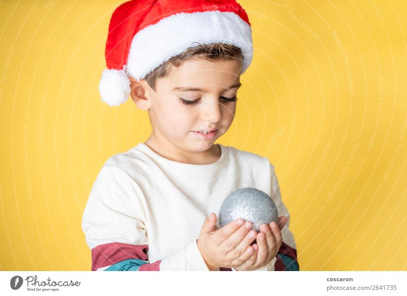 Süßes Kind mit Santa´s Hut und Weihnachtskugel Lifestyle Freude Glück schön Ferien & Urlaub & Reisen Winter Dekoration & Verzierung Feste & Feiern