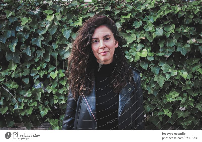 Porträt einer jungen Frau in Lederjacke vor einer begrünten Wand Lifestyle Glück schön Gesicht Mensch Natur Pflanze Herbst Efeu Blatt Park Felsen Mode Jacke