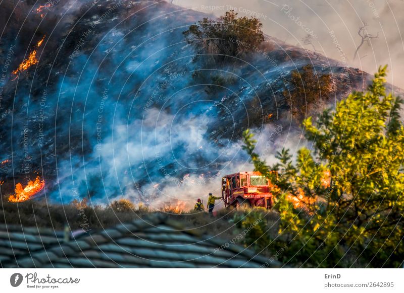 Zwei Feuerwehrleute lehnen sich auf Bulldozer mit brennendem Hang ab. schön Umwelt Landschaft Hügel Coolness einzigartig Mut Angst Farbe Zerstörung Bürste